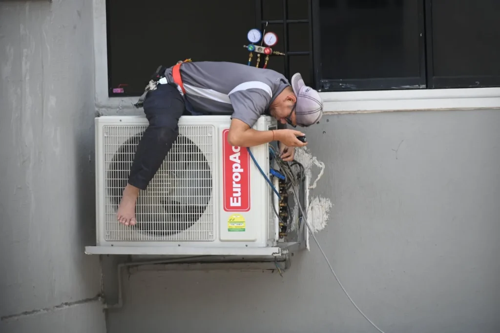 HVAC technician repairing an outdoor air conditioning unit