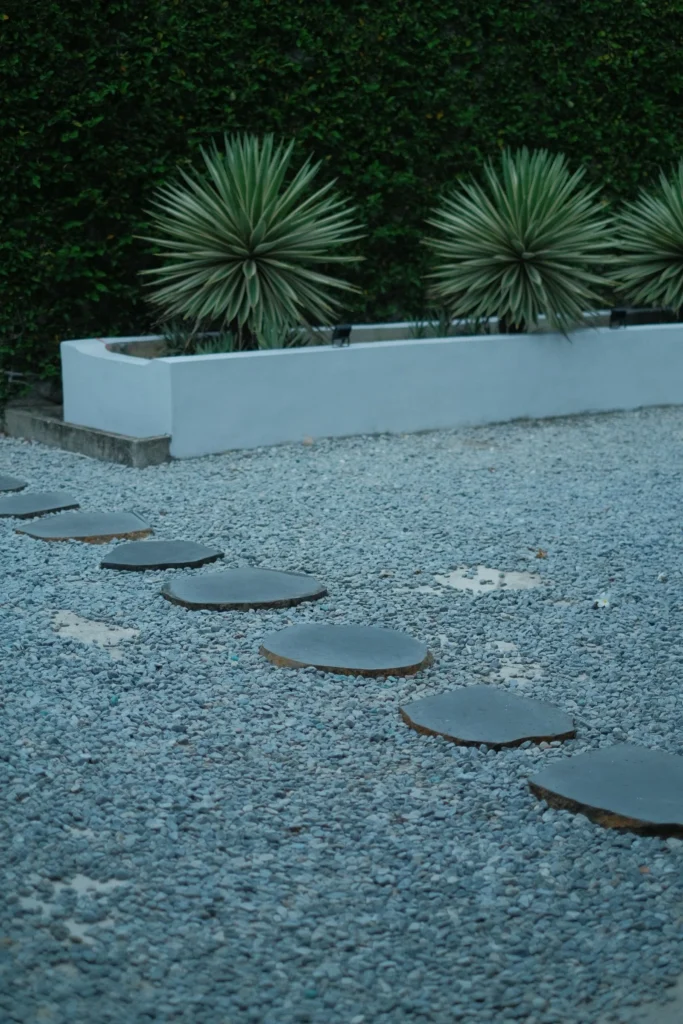 Modern water-wise garden with a circular stone pathway, agave plants, and gravel