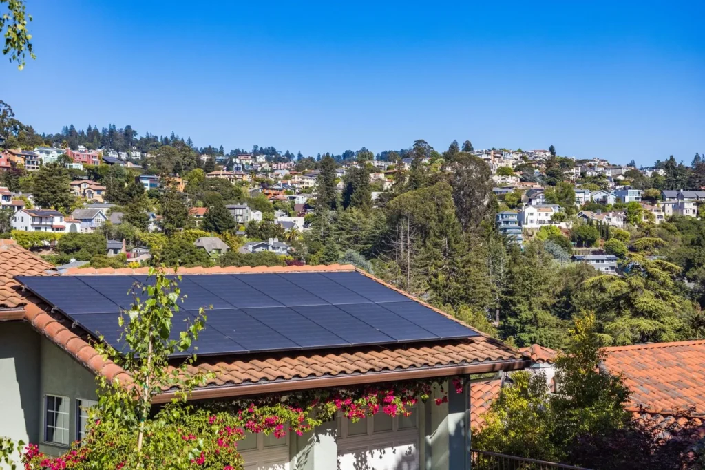 Solar panels on a suburban home under a sunny blue sky
