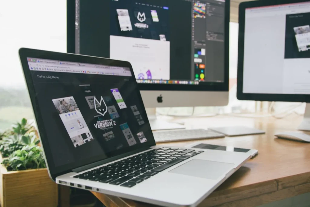 Workspace with a laptop and monitors used for contractor website design